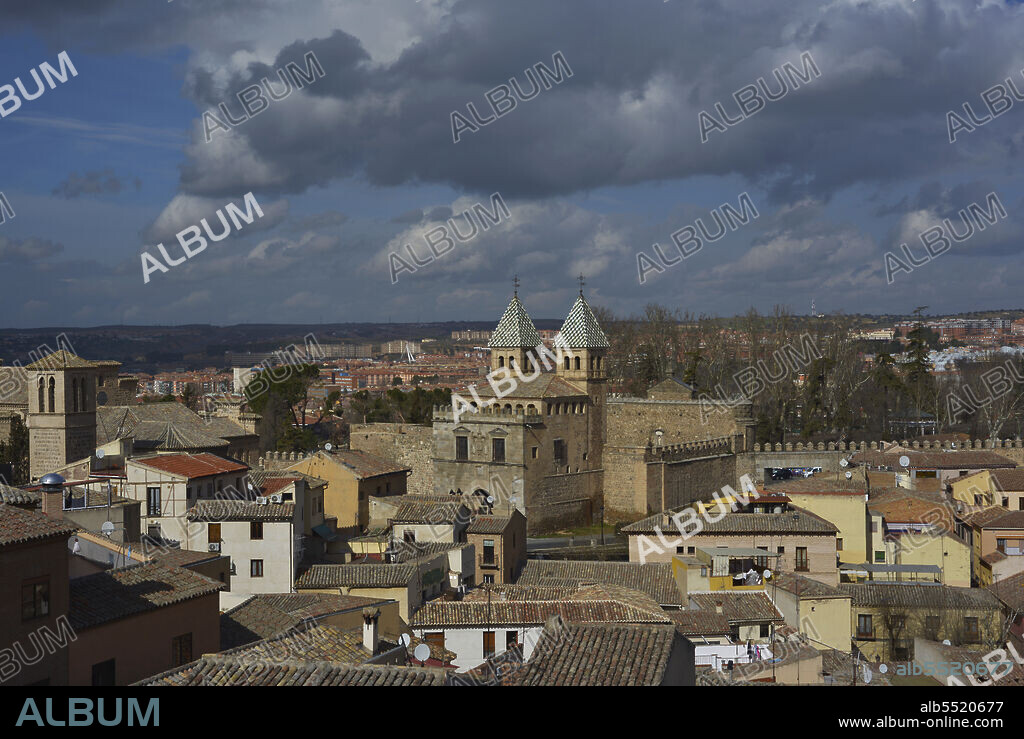 Spain, Toledo. Panoramic view of the city in which it can be seen the New Bisagra Gate (Puerta Nueva de Bisagra) of Moorish origin, rebuilt in the 16th century by Alonso de Covarrubias (1488-1570). On the left, the Church of Santiago el Mayor, built in the 13th century in Mudejar style. Restored in the 20th century.