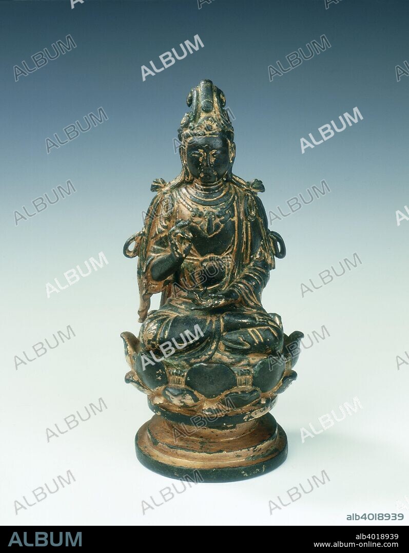Gilt bronze statue of bodhisattva on lotus seat, Liao dynasty, China, mid 11th century. A gilt bronze bodhisattva, sitting in the meditation posture with one hand raised in the gesture of blessing, on a lotus plinth with some everted petals. The headdress is of characteristic Liao form swept up and over, and the gilding is extensively worn.