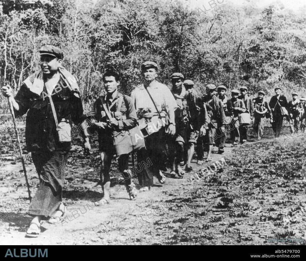 In a staged photograph, a troop of Khmer Rouge guerrillas file through the jungle of western Cambodia. Pol Pot strides out in the lead, followed by his personal bodyguard and then Brother No 2, Nuon Chea. Ieng Sary (in black) is 11th from left. The message to the Vietnamese and the outside world: 'We're still here and a viable force'.