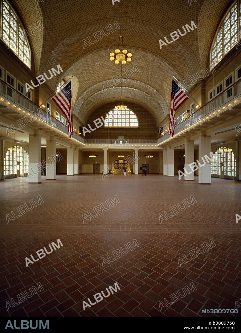 Interior view of the Great Hall of the Ellis Island Immigration Museum. The building is one of New York's few grand-scale brick buildings. The vaulted ceiling is the work of the Gustavinos, a family of tile makers from Spain. It was installed in 1918. The room itself is 338 feet long by 168 feet wide. This was the room into which immigrants were first brought into to be examined and processed. It was restored in 1991 and is now part of the Ellis Island Statue of Liberty National Monument. The island is located at the mouth of New York Harbor on the New Jersey side of the Hudson River. The ownership of the island is shared by the two states.