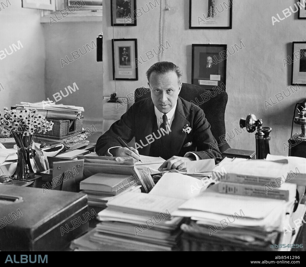 Orig. bildtext... MALTA. Sir Harry Charles Luke, C.M.G. Lieutenant Governor of the Island of Malta, photographed in his simple office in the Palace at Valletta, Malta, on his return from England. He was Knighted in the New Years Honours list for his wonderful work in Malta. Anm. Blicken Skrivbord Fotografier Riddare Guvernörer Slipsnålar Kostymer persons: SIR HARRY CHARLES LUKE sites: VALETTA;STORBRITANNIEN;MALTA.