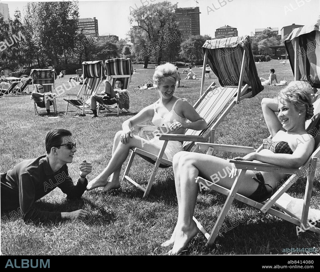 STOCKHOLM 1963-05-29. Rålambshovsparken, Rålis kallad.. De solbadande flickorna Siv Rosén från Lillhärad och Kerstin Anderzon från Östersund (som senare blev en känd skådespelerska under namnet Kim Anderzon) pratar med Staffan Burling. Foto Bengt Almquist / DN / SCANPIX / Kod 1.