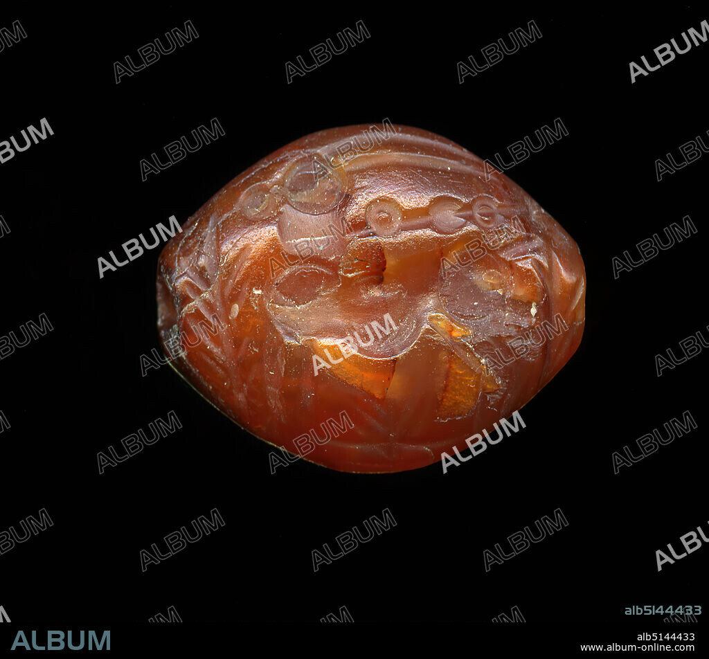 Stamp seal (Bezoar goat hit by a throwing spear), Kunststitfung, Carnelian, cut, drilled, Total: Height: 1,64 cm; Width: 2,02 cm; Depth: 0,88 cm, Body ornamentation, glyptic, goat, Capricorn, The intaglio shows a standing Bezoar goat or Capricorn on the front side. The animal is surrounded by branches, undergrowth or plants. In its neck is a throwing spear. The small rings indicate a knot shaft. A whole group of gems shows only the hit animal; mostly it is wild goats, ibexes or antelopes, rarely cattle. The old motif, taken over from the Orient, is often used in the group of the later so-called island stones as well as on the Graeco-Persian gems.