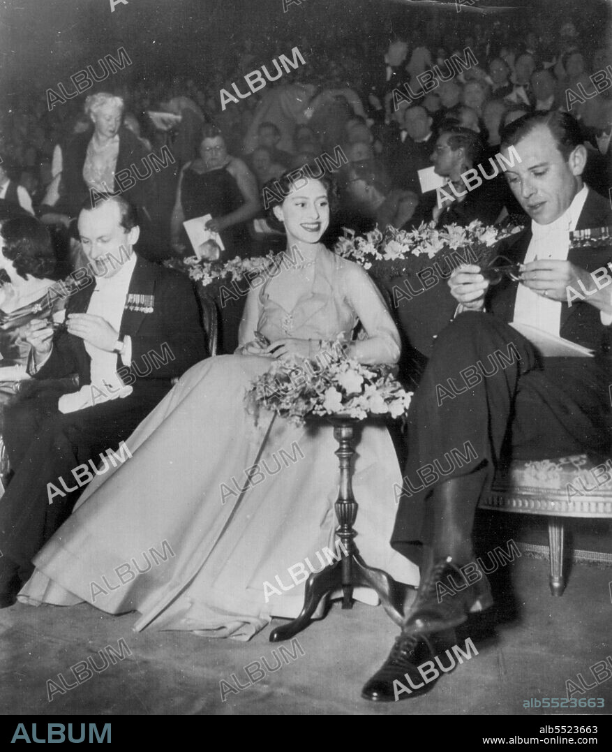 A Different View -- Princess Margaret smiles as she watches Denys Rhodes, right, adjust glasses to view three-dimentional movie at the Empire Theatre in London Feb. 22. The Princess in seeing the 3-D film, is the first member of the British Royal Family to see such a motion picture.. At left in Bonham Carter. Rhodes wife is a cousin of the Princess. The formally attired Princess holds gold-rimmed paid of glasses presented to her for viewing the film. February 24, 1954. (Photo by AP Wirephoto).