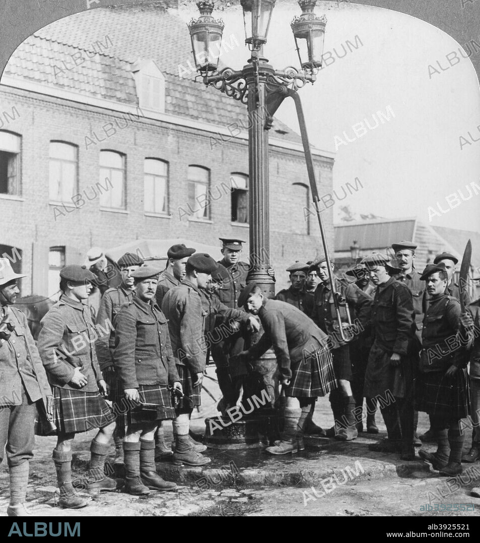 Soldiers filling their water bottles at the town pump La Gorgue, France, World War I, c1914-c1918. Men of the Seaforth Highlanders Regiment. Stereoscopic card. Detail.
