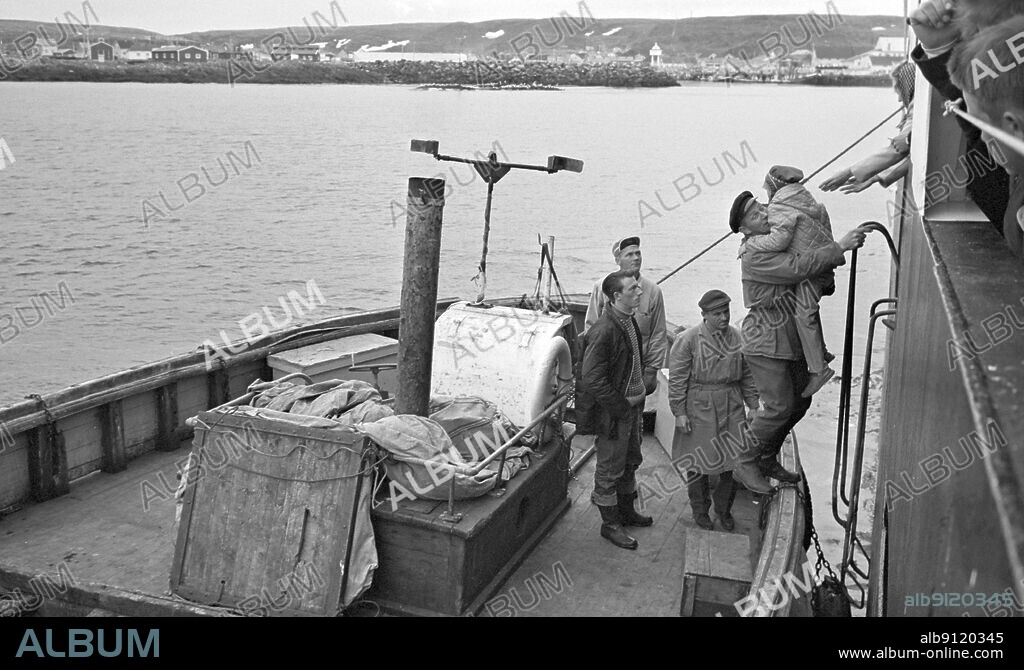 Northern Norway 1965-07-24 Tourists in Hotel Hurtigruta Tourists who want to see as much of Norway as possible, and the midnight sun, take the fast route from Bergen to Kirkenes and back again. They live in a floating hotel that takes them to small places and cities along the coast. In Berlevåg, an expedition boat came out to the Hurtigruta with passengers and fishing boxes. Photo: Sverre A. Børretzen / Current / NTB.
