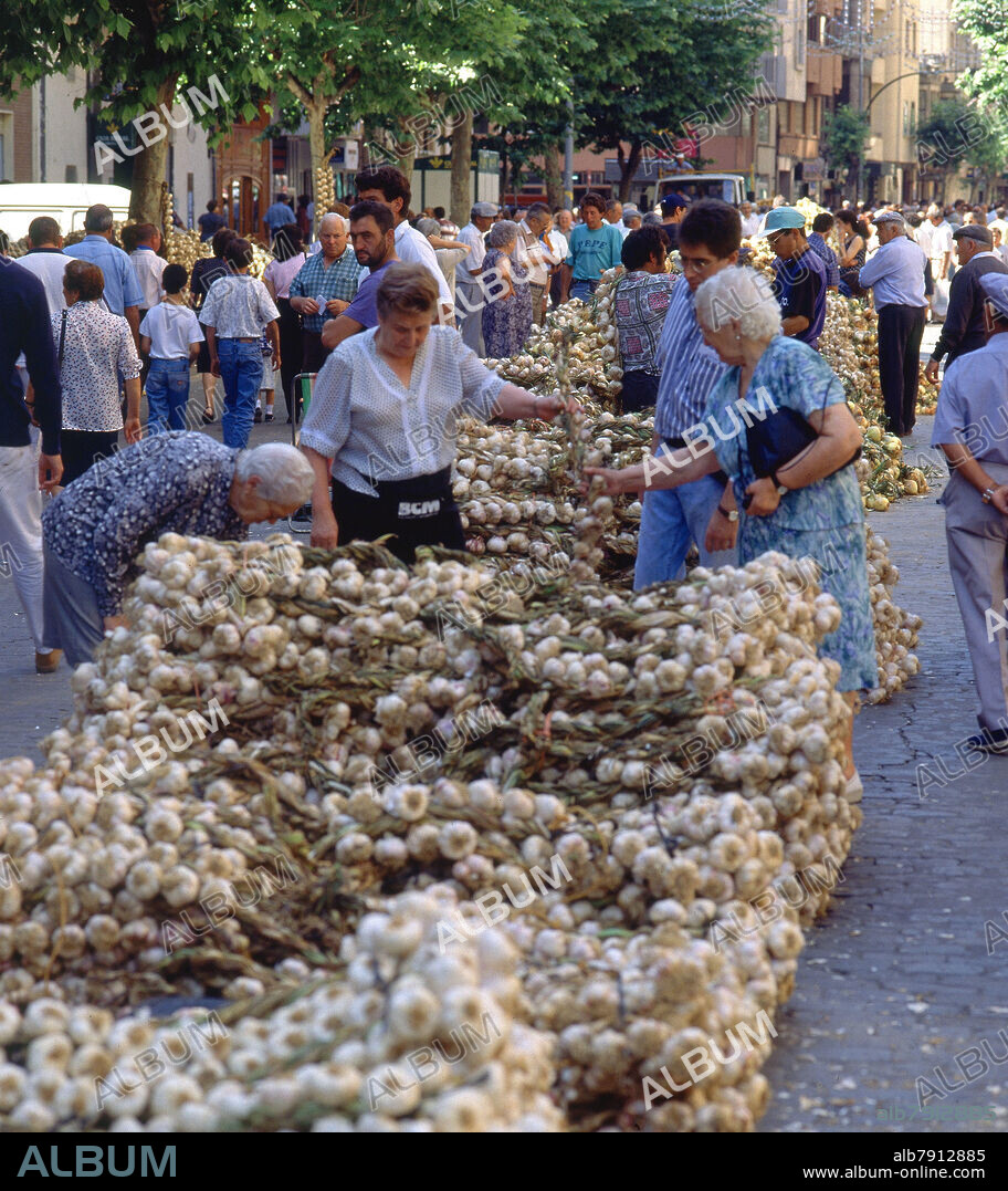 PUESTO CON RISTRAS DE AJOS AMONTONADAS-VENDEDORA.