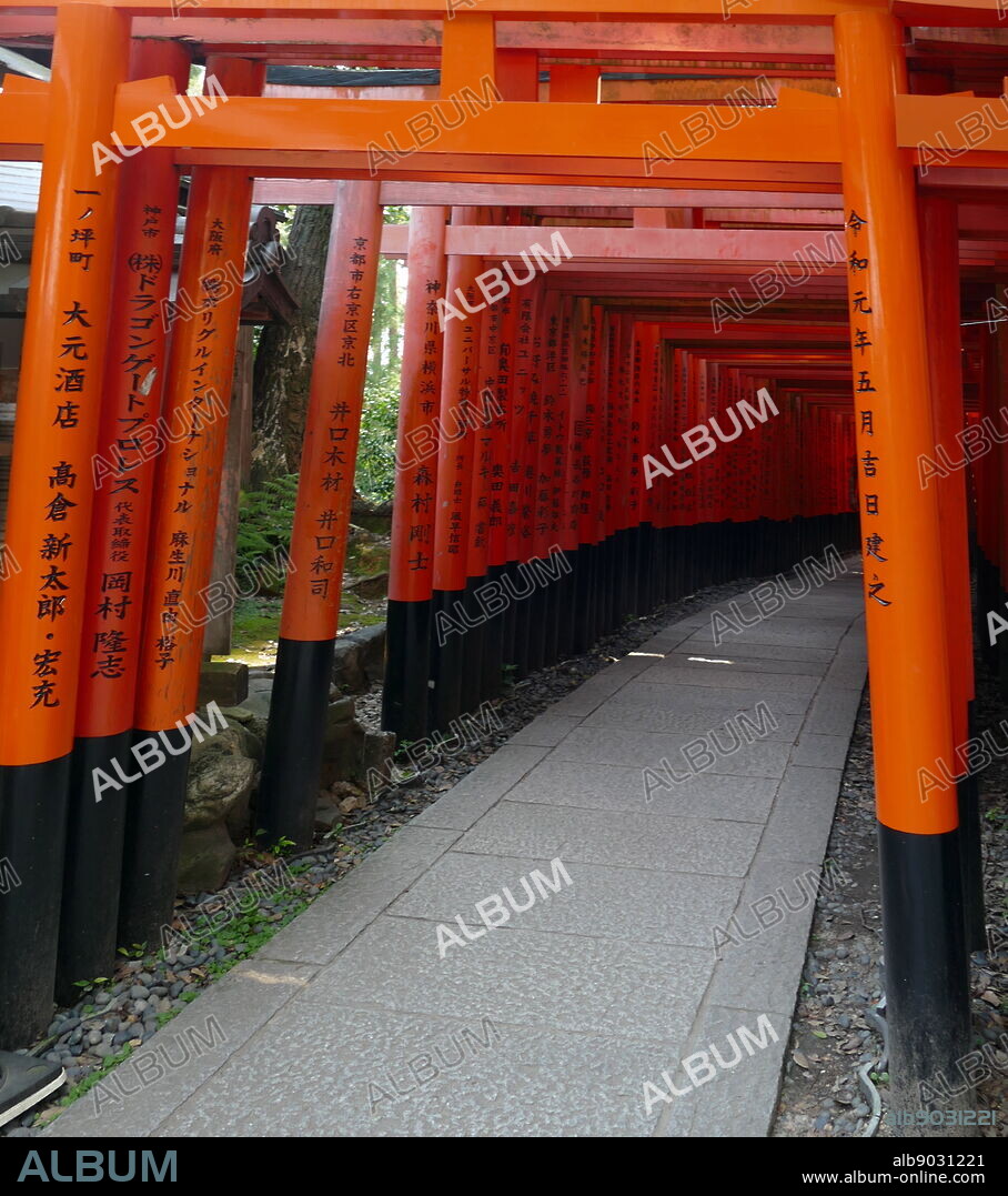 Fushimi Inari-taisha shrine, in Fushimi-ku, Kyoto, Japan. The shrine sits at the base of a mountain also named Inari. First and foremost, Inari is the kami of rice, but merchants and manufacturers have traditionally worshiped Inari as the patron of business. Each of the tori at Fushimi Inari-taisha has been donated by a Japanese business. The shrine became the object of imperial patronage during the early Heian period. In 965, Emperor Murakami decreed that messengers carry written accounts of important events to the guardian kami of Japan. The earliest structures were built in 711 on the Inariyama hill in south-western Kyoto, but the shrine was re-located in 816 on the request of the monk Kukai. The main shrine structure was built in 1499.