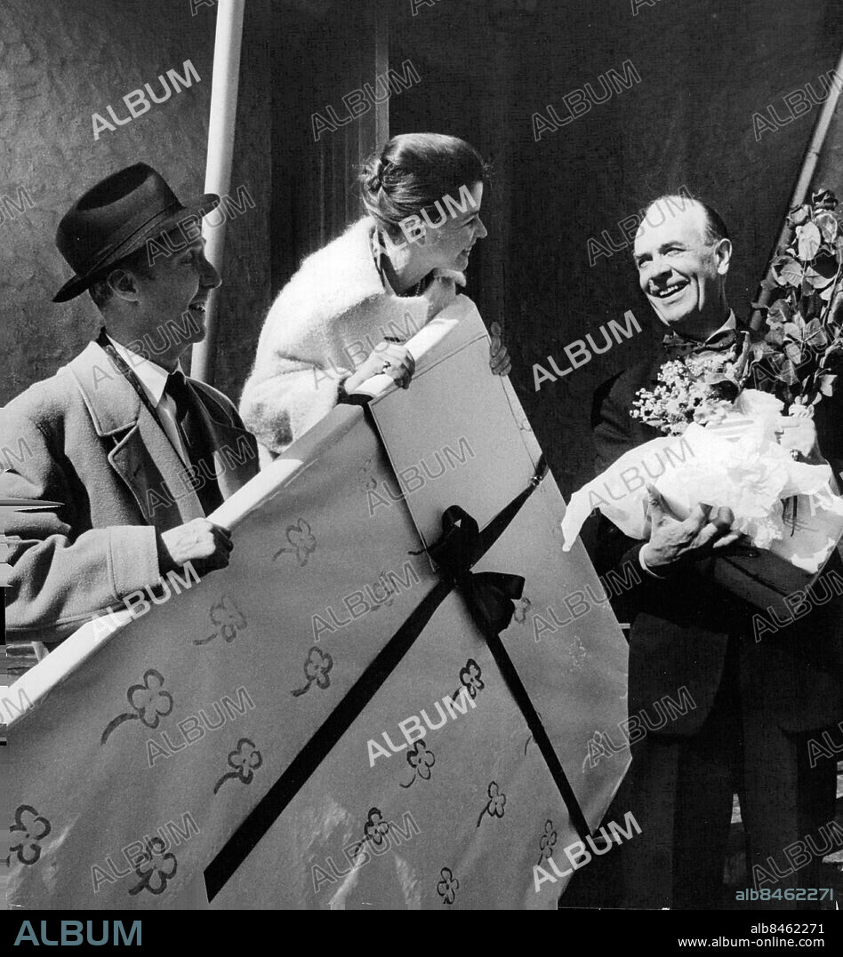 Saltsjöbadet 1961-04-15. Karl Gerhard fyller år. Sonen Per Gerhard och Maj-Britt Nilsson uppvaktar med ett jättepaket som Karl tar emot på trappan till Saltsjöbadshemmet. Foto: Jan Ehnemark / SvD / TT / kod 12014.
