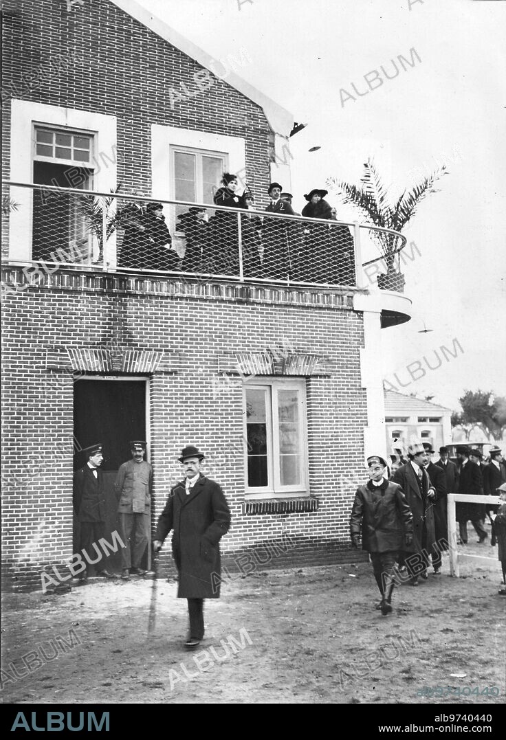 18 noviembre 1915. En la escuela nacional de Aviación. Su majestad el Rey (1) y la Reina doña Victoria (2), en el balcón del edificio de Talleres, Inaugurado Ayer, Presenciando la Llegada de los Aeroplanos Militares.