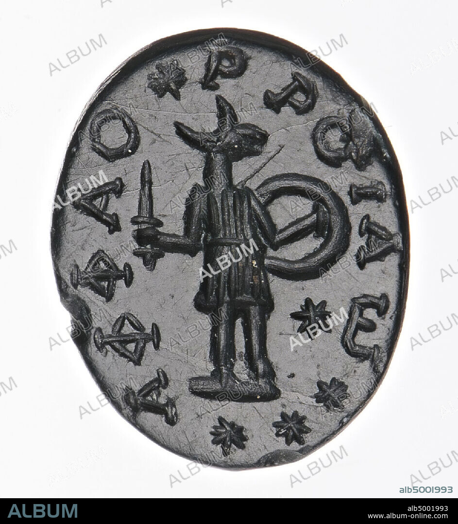 Vz: the god is dressed in a short tunic, frontal except the head in profile to the right, in his right hand he has a sword upright, in his left hand he has a shield, around an inscription., Gem, intaglio , amulet, jasper, Color: dark green, Shape: oval, Processing: edge cut back at the back compared to the front, Method: modeling and detailing with rounded wheel grooves., 23.5 x 11 mm, D. 2 mm, 2nd century BC. - 7th century AD. -200 BC.
