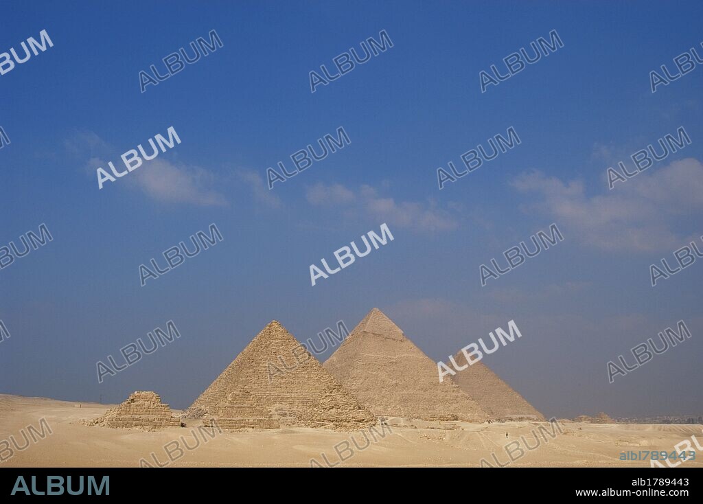 ARTE EGIPCIO. Vista desde el mirador de las tres pirámides. De izquierda a derecha: PIRAMIDE DE MENKAURA (MICERINOS), con sus tres pequeñas pirámides satélites. La PIRAMIDE DE JAFRA (KEFREN), que conserva intacta la capa de piedra caliza que recubre la cúspide. La Gran PIRAMIDE DE JAFU (KEOPS). IMPERIO ANTIGUO. IV DINASTIA. Siglo XXVI a. C. Meseta de EL GIZA. Egipto.