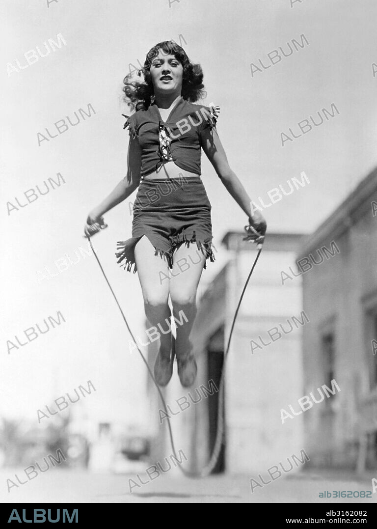 Los Angeles, California: c. 1929. Actress Sally O'Neil jumps rope between shooting scenes of " The Mysterious Island".