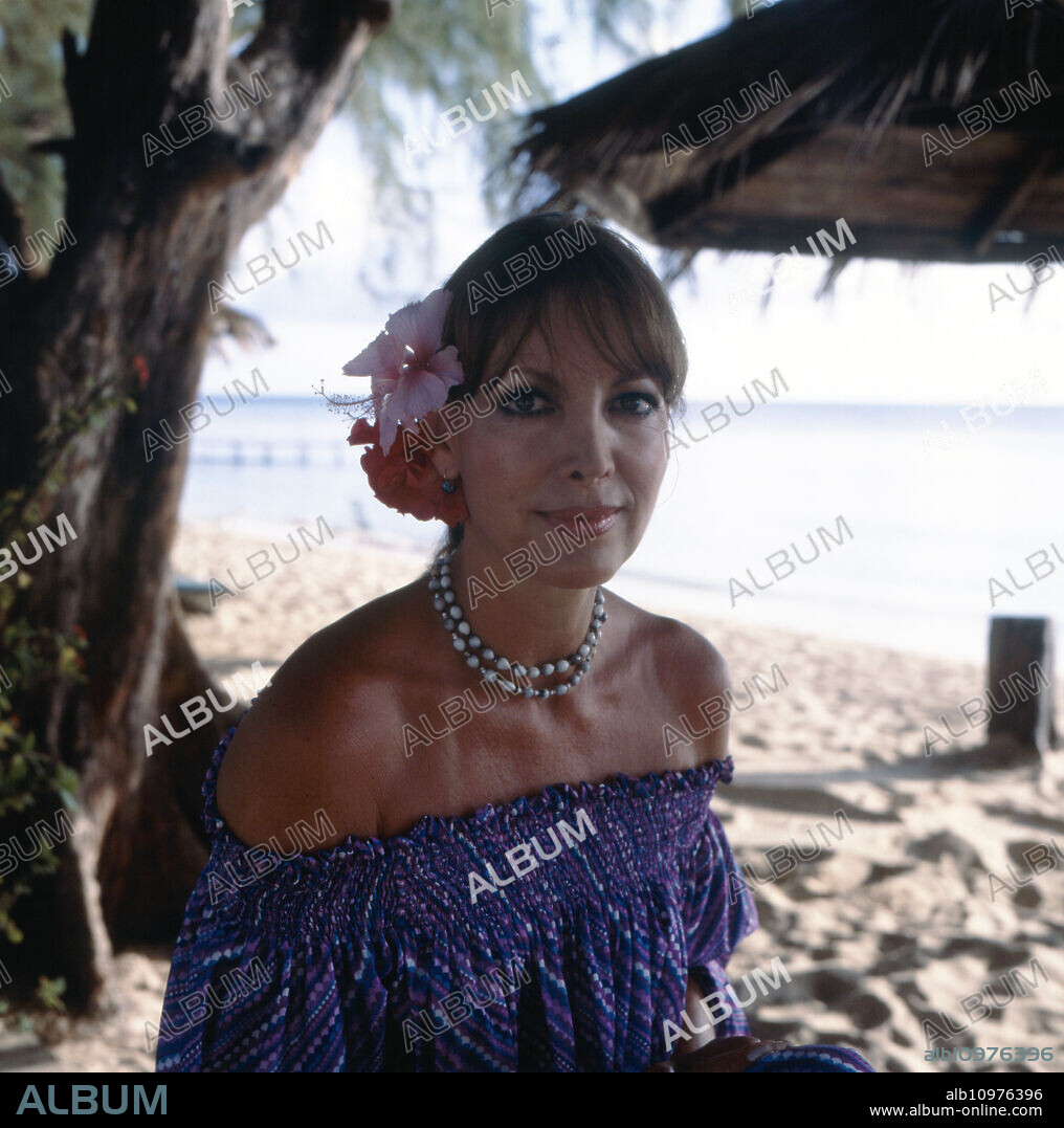 Portrait of the German TV presenter, programme announcer, actress and former Miss World Petra Schürmann posing on the beach with flowers in her hair, circa 1978.