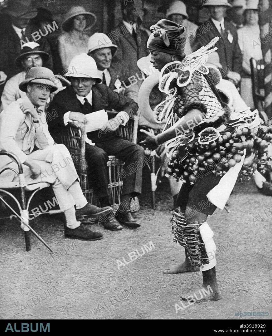 The Prince of Wales watching a traditional native beauty dance, Freetown, Sierra Leone, 1925. The future King Edward VIII enjoys a cultural event during a royal visit. Illustration from George V and Edward VIII, A Royal Souvenir, by FGH Salusbury, a souvenir book published as Edward VIII was crowned following the death of his father, George V, (Daily Express Publication, London, 1936).
