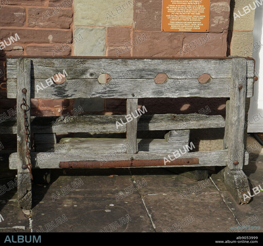 A replica of medieval wooden stocks. Stocks were restraining devices used as a formal of corporal punishment and public humiliation.