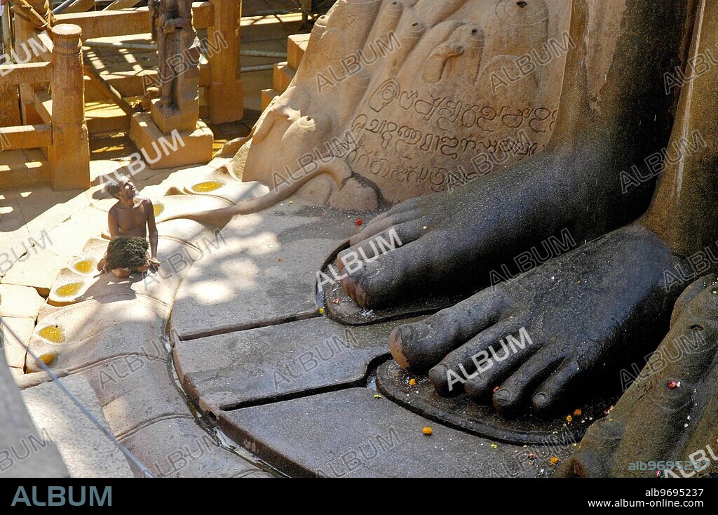 SUB102813 : Naked Jain muni or sadhu at the feet of Lord Bahubali during Mastakabhishek which happens after every 12 years, Shravanbelgola, Karnataka, India.