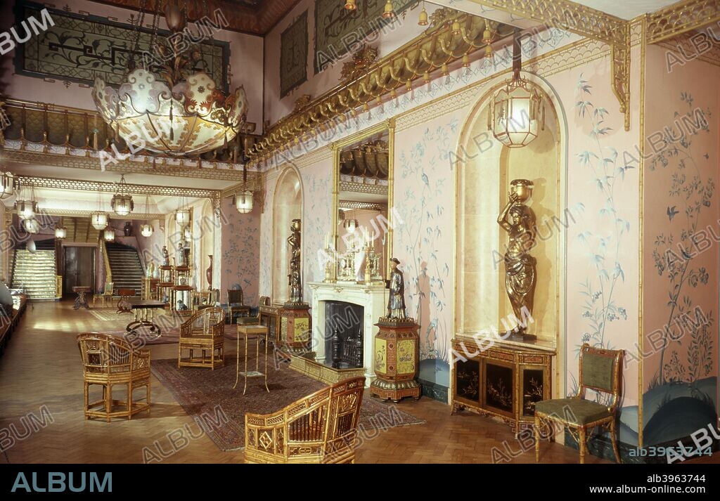 Interior, Royal Pavilion, Brighton, East Sussex, 1960s. Chinese-inspired hall with fireplace, mirror, furniture and statues. The Pavilion was originally built in 1786-1787 by Henry Holland for King George IV (1762-1830), then Prince Regent. It was added to by William Porden in 1804-1806 and remodelled by John Nash between 1815 and 1822 in a European interpretation of Indian and Chinese architectural styles.