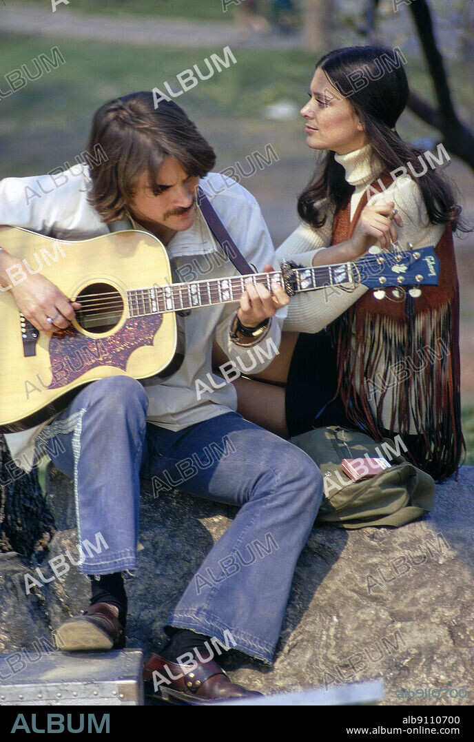 Young Adult Woman listening to Young Adult Man playing Acoustic Guitar, Central Park, New York City, New York, USA, Toni Frissell Collection, May 1970.