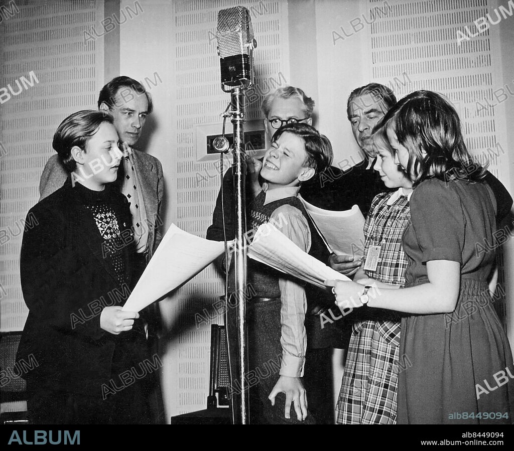 Orig. bildtext... Skolradio den 12/3 1945 : fr.v. Hans Lindgren, Olof Bergström, Bengt Kihlström, Nils Hultgren(skymd) Erland Colliander, Gerd Sundberg och Siv Hansson. Bengt Kihlström är just nära att bli överkörd, av en bil, därav det underliga ansiktsuttrycket. Anm. Inspelningar Skådespelare CD364 persons: SIV HANSSON;GERD SUNDBERG;ERLAND COLLIANDER;NILS HULTGREN;BENGT KIHLSTRÖM;OLOF BERGSTRÖM;HANS LINDGREN sites: SVERIGE.