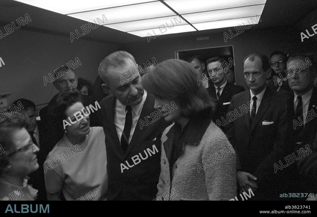Swearing in of Lyndon B. Johnson as President. Left to right: Judge Sarah Hughes, Jack Valenti, Congressman Albert Thomas (behind Mrs. Johnson), Lady Bird Johnson, President Lyndon B. Johnson, Jacqueline Kennedy, Lem Johns, Congressman Jack Brooks, Bill Moyers (in the back), Dr. Burkley. Johnson was sworn in as President on the Air Force One plane at Love Field in Dallas on November 22, 1963, just 2 hours and 8 minutes after John F. Kennedy was assassinated in Dallas, amid suspicions of a conspiracy against the government. He was sworn in by U.S. District Judge Sarah T. Hughes, a family friend, making him the first (and so far only) President sworn in by a woman. He is also the only President to have been sworn in upon Texas soil. In the rush, a Bible was not at hand, so Johnson took the oath of office using a Roman Catholic missal from President Kennedy's desk. Johnson being sworn in as president has become the most famous photo ever taken aboard a presidential aircraft. He was convinced of the need to make an immediate transition of power after the assassination to provide stability to a grieving nation under shock. In the days following the assassination, Lyndon B. Johnson made an address to Congress saying that "No memorial oration or eulogy could more eloquently honor President Kennedy's memory than the earliest possible passage of the Civil Rights Bill for which he fought so long." Photographed by Cecil Stoughton.