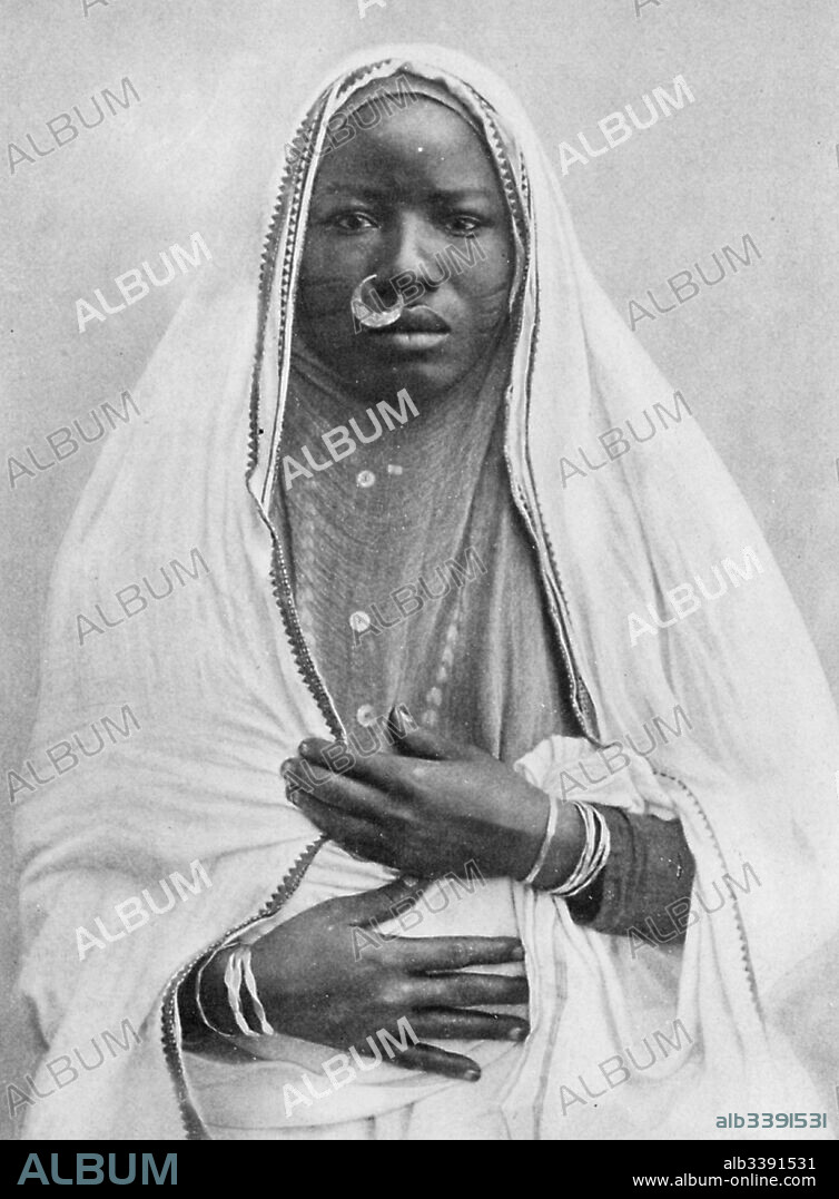Women wearing traditional native dress, including a veil and nose ring, Sudan, 1922.