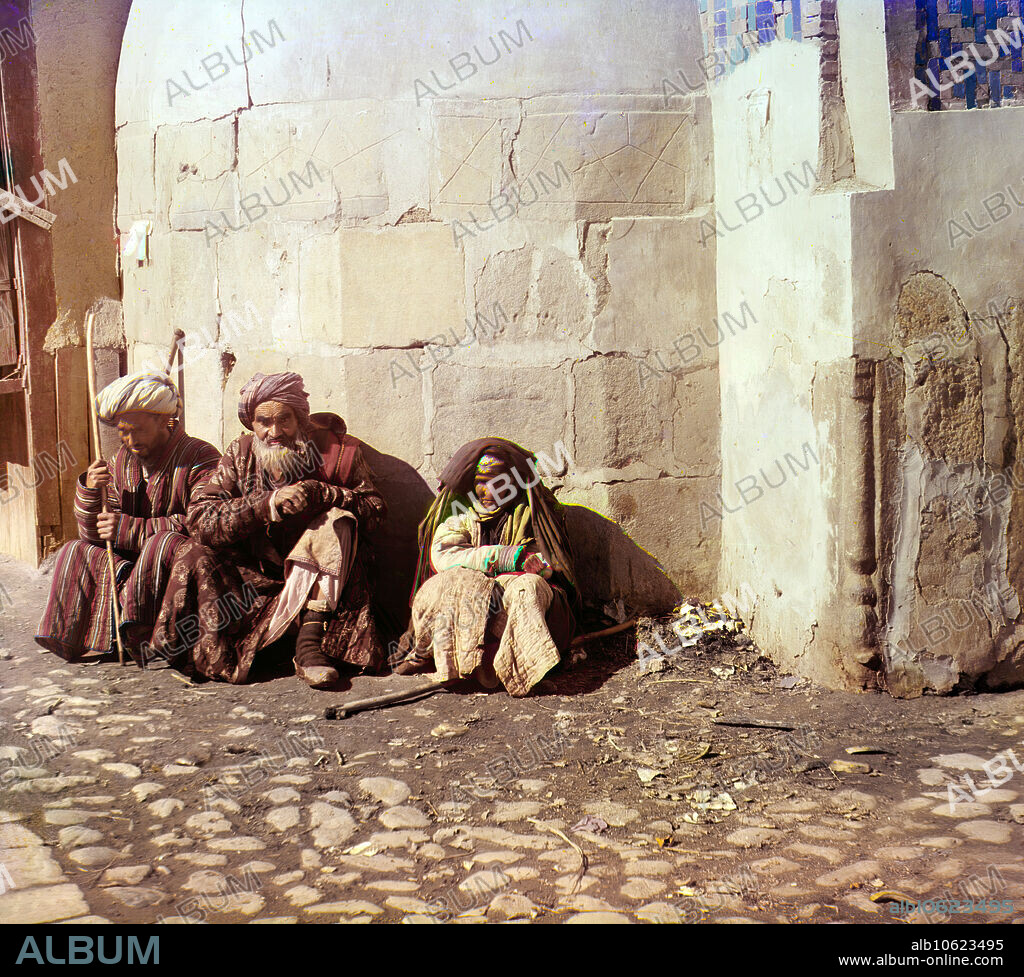 SERGEY MIKHAYLOVICH PROKUDIN-GORSKY. Beggars, Samarkand, between 1905 and 1915. Two men and a woman squatting against a building wall.  Russian chemist and photographer Sergey Prokudin-Gorsky (1863-1944) was a pioneer in colour photography which he used to document early 20th-century Russia and her empire, including the vanishing way of life of tribal peoples along the Silk Route in Central Asia. In a railway-carriage darkroom provided by Czar Nicholas II, Prokudin-Gorsky used the three-colour photography process to record traditional costumes and occupations, churches and mosques - many now Unesco World Heritage sites - as well as modernisation in agriculture, industry and transport.