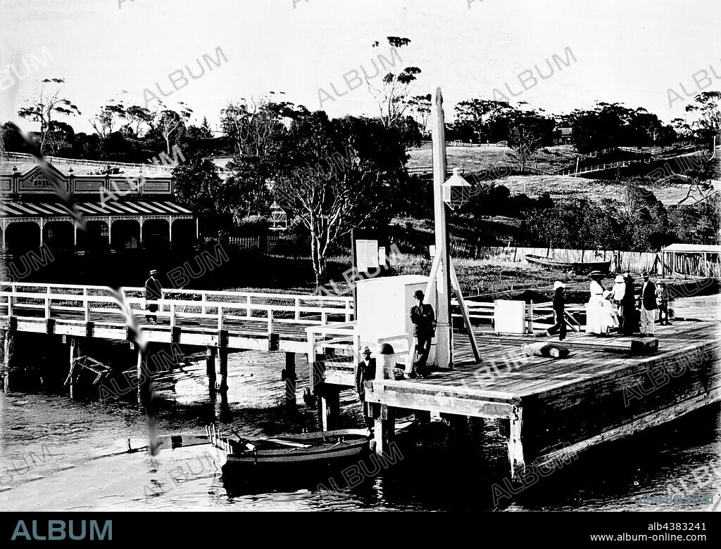 Negative - Metung, Victoria, circa 1905, The pier and the Scarborough Hotel. There is a boat moored beneath the pier and there are a number of men and women on the pier.