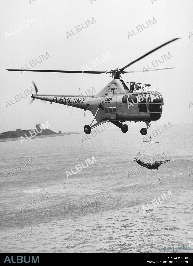 Demonstrating The Navy New Rescue Net -- A "Victim" is scooped out of the sea and carried like of the in the during a demonstration at Gosport today of the Royal Navy's latest and most efficient method of rescuing aircrash and other victims down in the Sea. It is a rescue scoop net and is the latest development of the use of the helicopter. January 24, 1955.