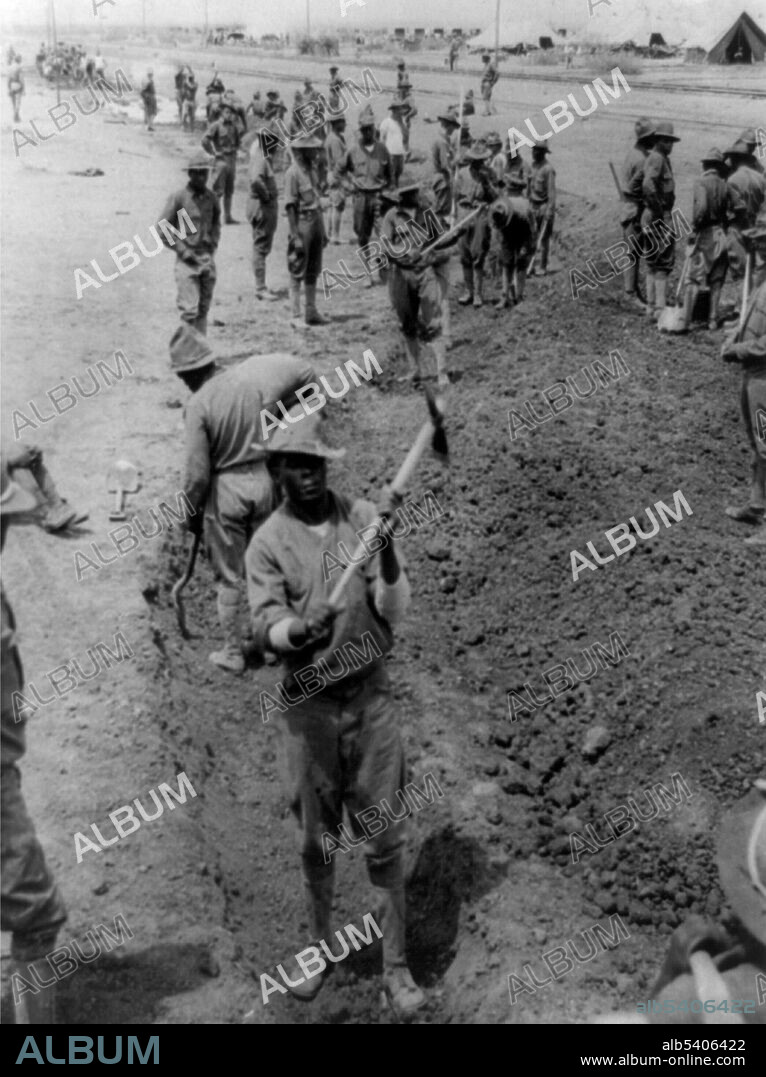 Soldiers digging a ditch for rain water to flow off. The Pancho Villa Expedition was a military operation conducted by the US Army against the forces of Mexican revolutionary Pancho Villa from March 1916 - February 1917, during the Mexican Revolution of 1910-20. The expedition was launched in retaliation for Villa's attack on the town of Columbus, New Mexico. William Fox for Underwood & Underwood, 1916. NOTE: both the 10th Cavalry and 24th Infantry were involved in the Expedition, but the photographer made no indication which regiment these men belonged to.