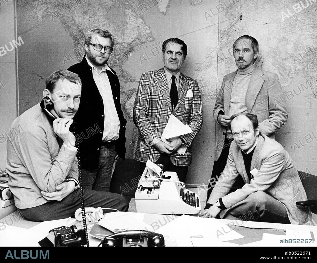 STOCKHOLM OKÄNT FOTODATUM.. Anm. Pub i boken Hört och sett. Sid.112 Ekoredaktionen samlad framför en bit av världen. I mitten programchefen Per Persson, som i centrala programledningen svarar för ekoprogrammen, samhälle, sport och de finska sändningarna. Sittande till höger Anders Wilhelmson, chef för Dagens eko, och bakom honom biträdande chefen Karl-Erik Olsson. Stående till vänster utrikeschefen Bo Karlström, sittande inrikeschefen Olle Söderlund. CD43 persons: ANDERS WILHELMSON;BO KARLSTRÖM;KARL-ERIK OLSSON;OLLE SÖDERLUND sites: SVERIGE;STOCKHOLM.