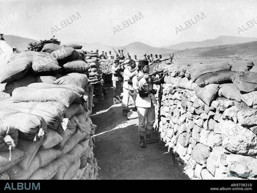 Trenches in the Outposts. Trenches of the Laucien camp above the Wad-Ras valley. Soldiers firing at the "Pacos" who are hiding in the undergrowth of the Llano. Photo of our special envoy Mr. Alba. Approximate date Melilla, 1913 (Ca.). Moroccan War, Trenches in the Outposts, from the Laucien camp above the Wad-Ras valley. Soldiers firing at the Pacos who are hiding in the undergrowth of the Llano.