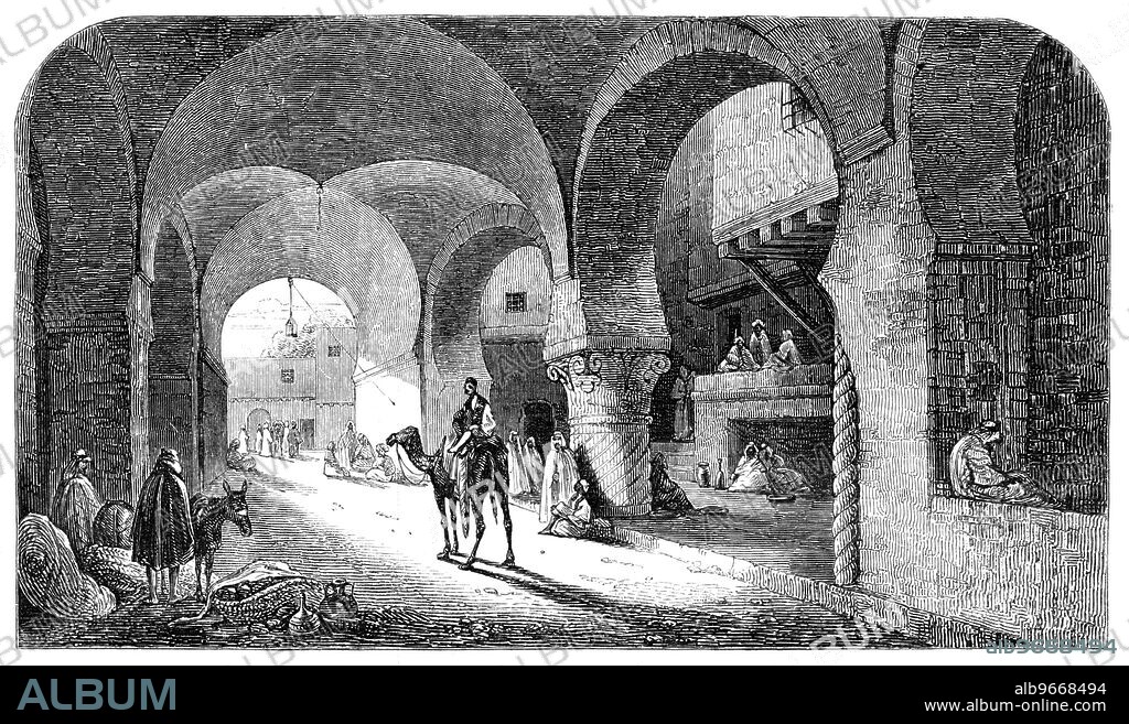 The Desert Route - Caravanserai, near El Arish, 1857. Middle Eastern scene. 'At the caravanserai gate hangs a large lantern, throwing a meagre light on the objects around. Camels and donkeys; men, women, children; an occasional goat, and a few stray hens, have here a common resting-place. Groups of travellers are assembled in various parts of the building making ready for the night: some have taken the wise precaution to mount up on the elevated platform in the building, to avoid as much as possible the plague of fleas; others, too weary to take this precaution, squat themselves down where they best can; some few are busy purchasing little requisites for their suppers from the scanty stalls of the venders many years established both outside and inside of the caravanserai'. From "Illustrated London News", 1857.
