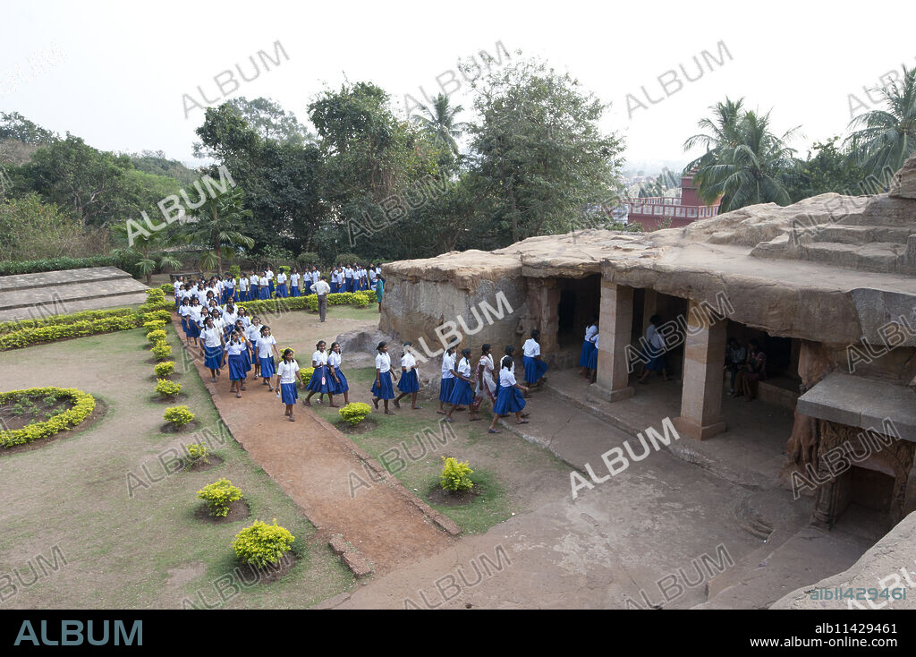 Local schoolchildren in blue and white school uniform visiting Ranigumpha, cave number 1, Udayagiri caves, Bhubaneshwar, Orissa, India, Asia.
