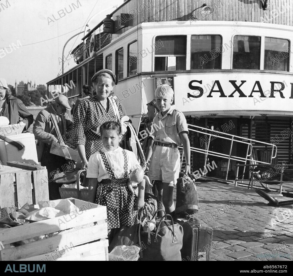 Stockholm 1955-08-28. På Strömkajen väntade fru Wivan Notini med barnen Per-Erik och Elisabet på en bil som kunde forsla all packning hem till Enskede. Foto: Boris Engström / DN / TT / Kod: 192. ** SvD OUT **.