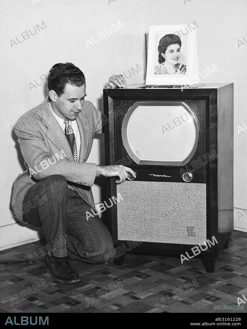 United States: c. 1955 A man adjusting his Motorola television set.