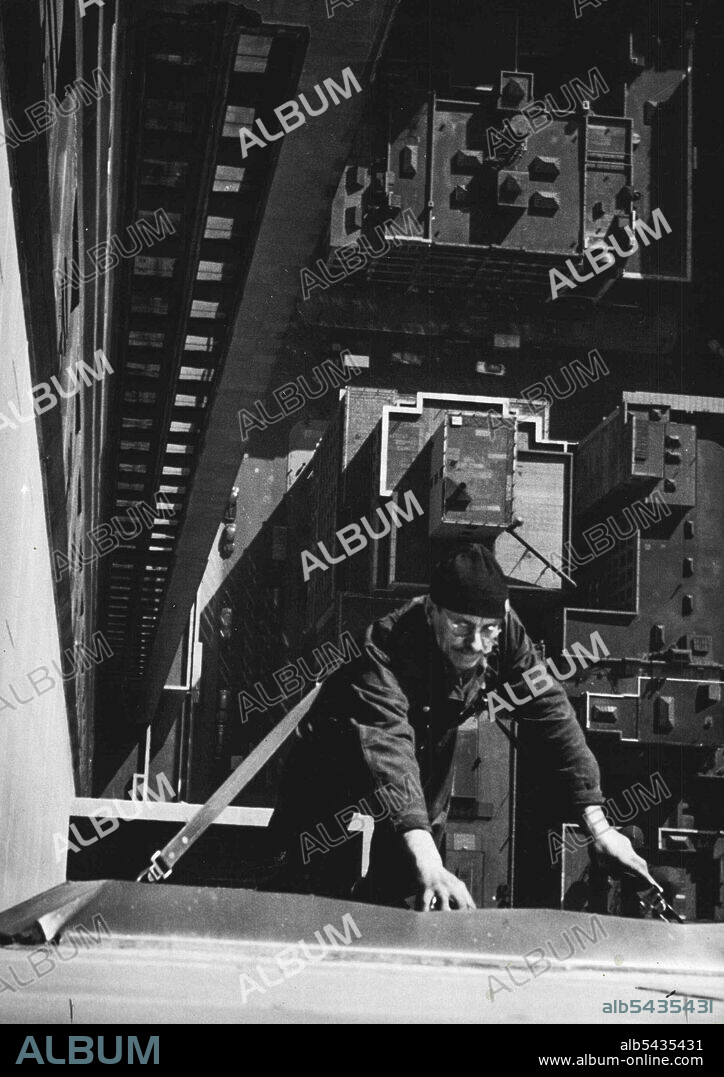 The Empire State building has 6,4000 windows, and the cleaning of them keeps a staff of 7 men busy every working day. This picture, taken from a set-back on the 81st floor, shows Richard Hart, foreman of the 7-man team, cleaning a window below on the 80th floor. Hart, born in the State of Maine, but a resident of Staten Island, one of New York's five boroughs, has been a window cleaner for some 30 years, and has cleaned the Empire State's windows since it was opened in 1931. Heights that would m.