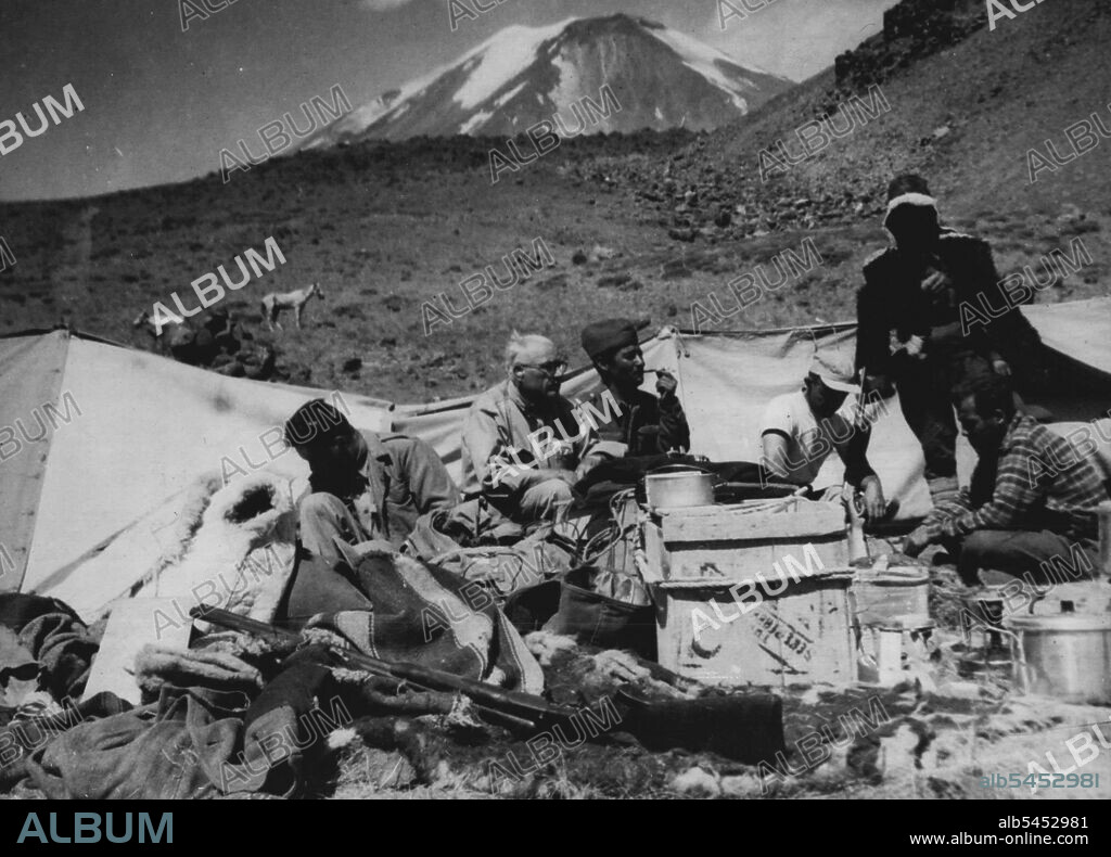 Looking For Noah's Ark -- This is the expedition's base camp, three miles from mount Ararat (in background). Sitting beside the equipment are left to right: E.J. Newton of Colfax, North Carolina, USA: Dr. Aaron J. Smith of Greensbord, North Carolina, leader of the expedition a Turkish army doctor (unidentified) Walter Wood, sea Cliff, long Island, USA: Wendell OGG, Knoxville, Tennessee, USA, and Dogan Poyarz of AP's Ankara bureau.After a five day search on three sides of Mount Ararat, Turkey, an American Archaeological Expedition found no trace of Noah's ark, for which it is Searoming.Members returned to their base camp early in September, and planned a further search on the north side. September 17, 1949. (Photo by Associated Press Photo).
