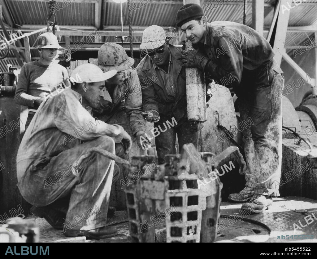 A drilling crew on the Rough Range No. 1 oil rig in Western Australia examine pieces of a broken drill after a successful "fishing" operation. The men used a magnet to retrieve the broken pieces from a depth of 9,908 feet. The welll is the exploratory one which yielded oil last year. West Australian Petroleum Pty. Ltd. has announced that No. 2 well has failed to produce oil at the horizon at which it was discovered in No. 1 well. August 05, 1954.