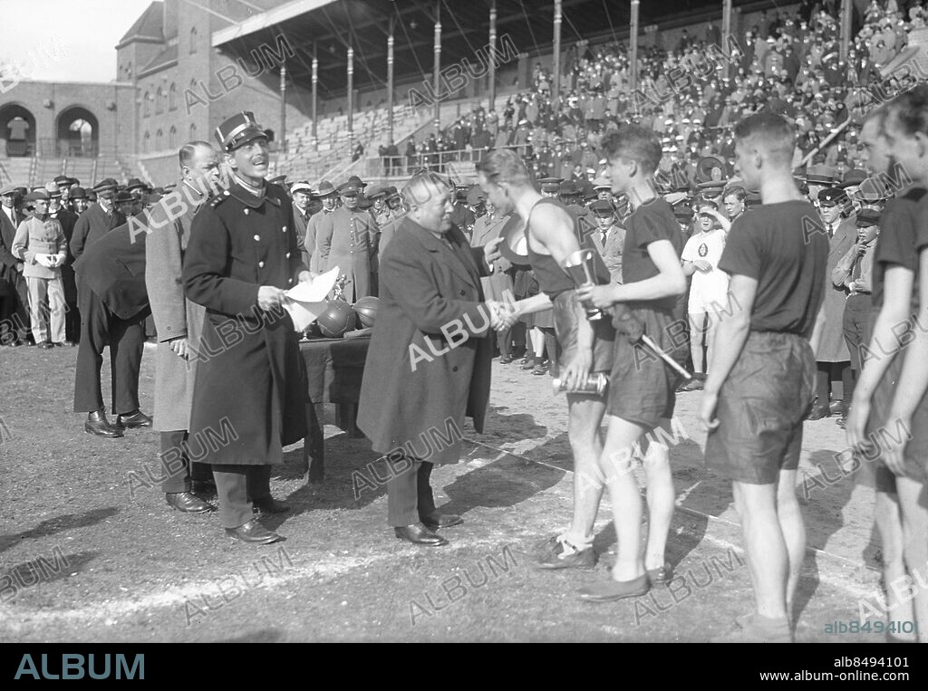 STOCKHOLM 1921. Skolungdomens tävlingar på Stockholms stadion. Stadsfullmäktiges ordförande Allan Cederberg är prisutdelare. Till vänster löjtnant Ernst Killander. Skolungdomens friidrottstävlingar arrangerades på Stadion där de bästa från landets alla skolor tävlade.. Foto: Pressens Bild / TT / Kod: 194.