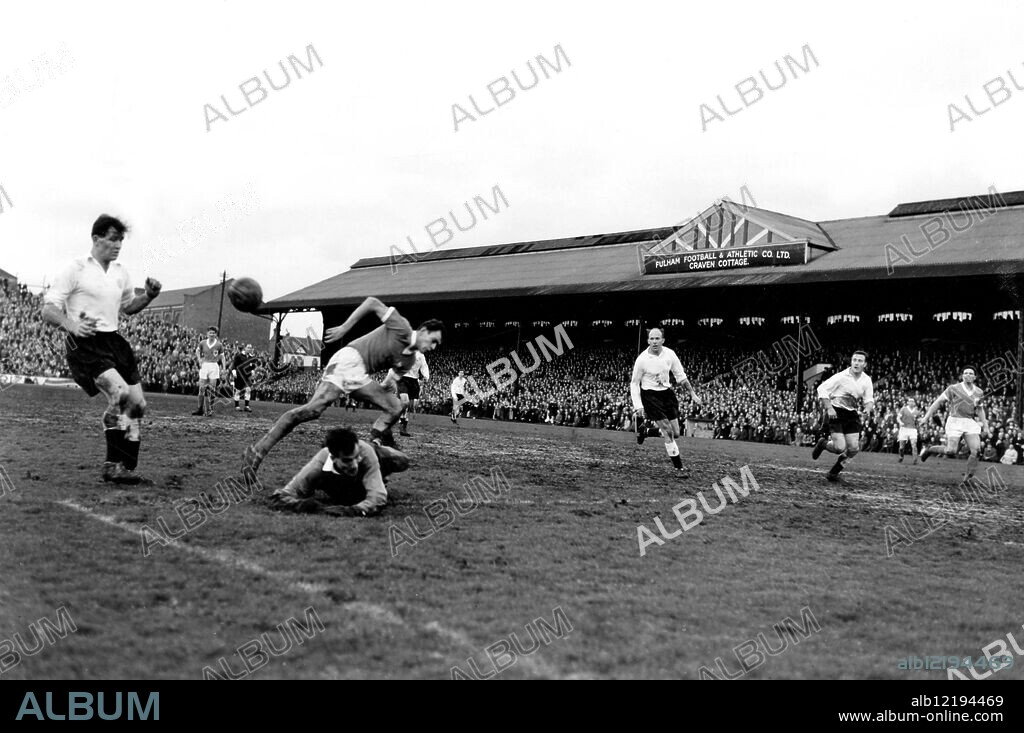 Fulham v Blackpool. Charnley, the Blackpool centre-forward, jumps over the fallen Fulham goalkeeper, Macedo, as the ball sails past in the other direction at Craven Cottage. 25th February 1961.