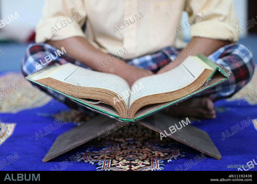 Muslim man reading the Quran in mosque, Ho Chi Minh City, Vietnam, Indochina, Southeast Asia, Asia.