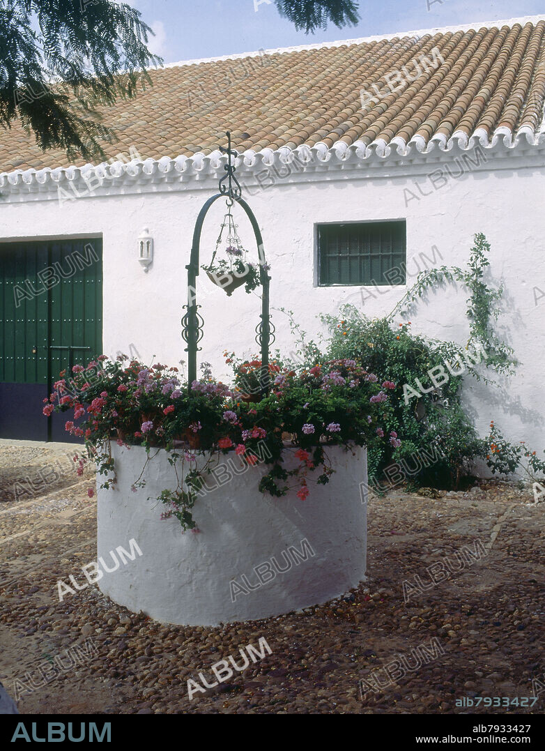 PATIO - SUELO DE CANTO RODADO- BROCAL DE POZO CON TIESTOS.