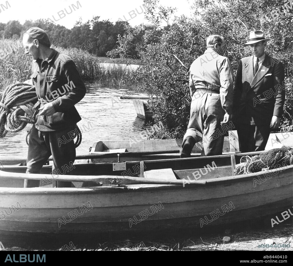 Skåne 1952-08-22. Massmördaren (fjärdingsmannen) Tore Hedin i Skåne 1951-1952.. Hedin mördade kvarnägaren Allan Nilsson i Tjörnarp med yxa. 21 augusti 1952 mördade han sina föräldrar och satte eld på föräldrahemmet i Saxtorp.. Han kör sedan till ålderdomshemmet i Hurva (Hurvamorden) där han mördar sin fästmö och föreståndarinnan med yxa. Han tänder sedan eld på hemmet och ytterligare fem personer dör.. På bilden draggar civilklädda poliser, polismän efter Tore Hedin i Bosarpssjön.. Foto x / Sydsvenskan / SCANPIX. **OUT Kvällsposten, Skånska Dagbladet, Metro Skåne**. ***BETALBILD***.