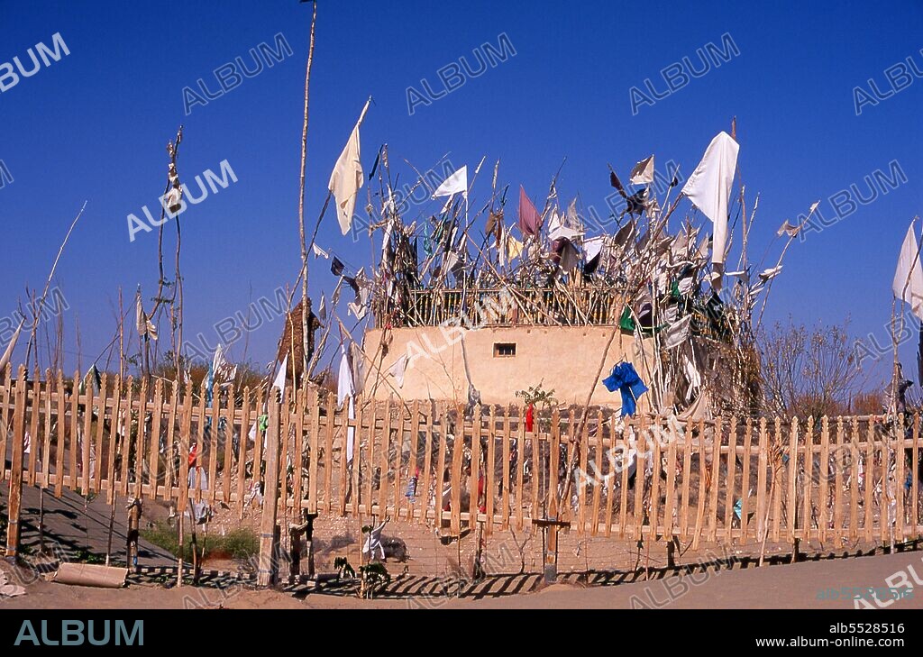 The Imam Asim Shrine and other tombs can be found 23 kilometres from Khotan (Hotan) on the southern Silk Road. It is the site of a huge pilgrimage each May. Imam Asim was one of the first Islamic missionaries to visit this area. Khotan traces its history back at least as far as the 3rd century BCE, when the eldest son of the Indian emperor Asoka is said to have settled here. It was of great importance on the Silk Road, and is claimed to have been the first place outside China to have cultivated silk. It sits astride the Karakash or ‘Black Jade’ and Yurungkash or ‘White Jade’ Rivers, which here conjoin to form the Khotan Darya, and has been famous for its jade for well over two millennia. In times past trade routes crossed the desert to the north all the way to Kuqa, and as recently as 2007 this link has been re-established for the first time in centuries with the opening of a second Desert Highway leading to Aksu, distant some 424km to the north. In 1006 Khotan was conquered by Uighur Muslims from Kashgar, and since that time the city remains a very Uighur place.
