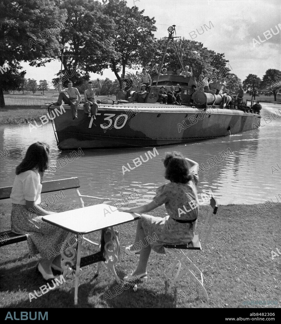 ARKIV CA 19460730. Motortorpedbåt T30 åker utmed Göta Kanal där besättningen sitter ute på skrovet och vinkar till ett par kvinnor som sitter utmed kanalkanten sommaren 1946.. Foto: Expressen / SCANPIX / Kod: 192.