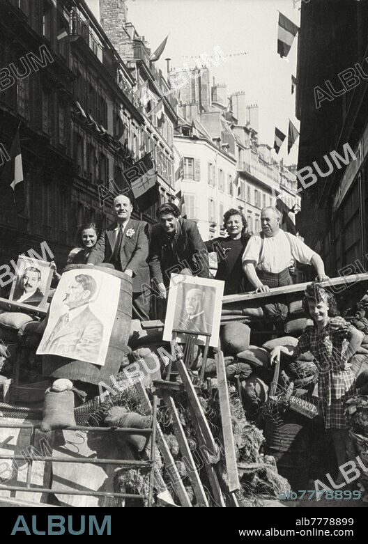 History / World War II: France. "Libération" of Paris on 25th August 1944. Happy Parisians after the liberation posing on a barricade errected during the street war between the Résistance and the German troops (19.- 24. August 1944). Photo.