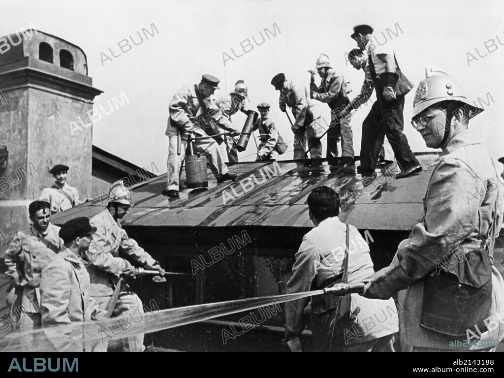 world war ll, composer dmitri shostakovich (right), member of the volunteer fire fighting squad of the leningrad conservatory, during a drill in which he and the other teachers learn to handle incendiary bombs.