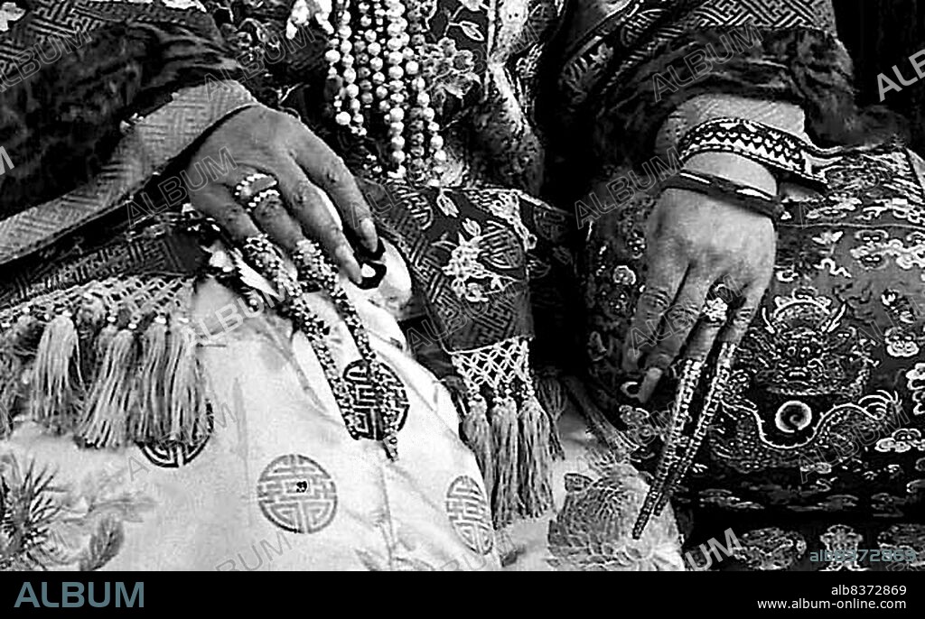 Western descriptions of Chinese emperors, royalty and nobles often mention fingernails long enough to mark the person above any possibility of manual labor. These fingernail protectors, or guards, might be worn as a single jewel on the hand or in multiple sets.<br/><br/>. According to the San Diego Museum of Art: 'Fingernail protectors were worn by a very elite groupManchu court ladies of the late Qing dynasty. Although scholars of Chinese costumes usually date fingernail protectors to the Qing dynasty, they are in fact characteristic only of the late 19th century. Portraits of early Qing court ladies show natural fingernails. Late Qing rulers, however, pursued a life of absolute luxury. For example, photographs and portraits of Empress Jixi (1835-1908) show her wearing two or three nail shields on each of her handsa sign of her ability to rely upon servants to carry out any of her wishes, as she herself could perform no manual tasks'.<br/><br/>. The wearing of fingernail protectors was specifically associated with the Manchurian high culture of the Qing Dynasty. Han men were forced by law to wear Manchu clothing and to groom themselves by Manchu custom, whereas Han women were free to continue wearing traditional Han fashions. Manchu women felt that long fingernails were a status symbol they protected with fingernail covers that might be finely carved and inlayed with gold silver and gem.
