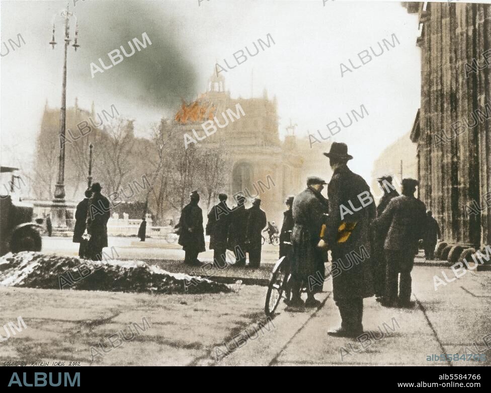 Reichstagsbrand, 27. Februar 1933. (Das Reichstagsgebäude wird in der Nacht vom 27. auf den 28. Februar durch Brandstiftung größtenteils zerstört). Blick vom Brandenburger Tor auf das brennende Reichstagsgebäude am Morgen des 28. Februar. Foto; spätere Kolorierung.